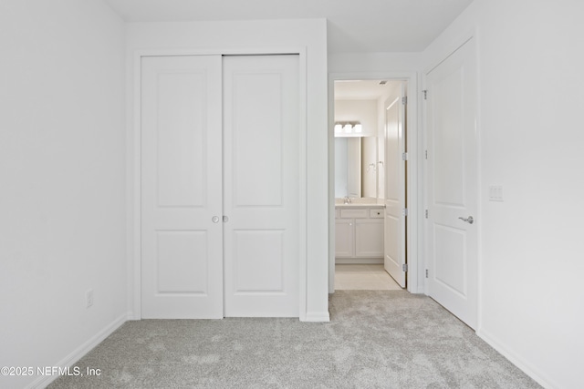 2413 Glade Ln, Green Cove Springs, FL 32043 - unfurnished bedroom with light carpet, a closet, baseboards, ensuite bathroom, and a sink