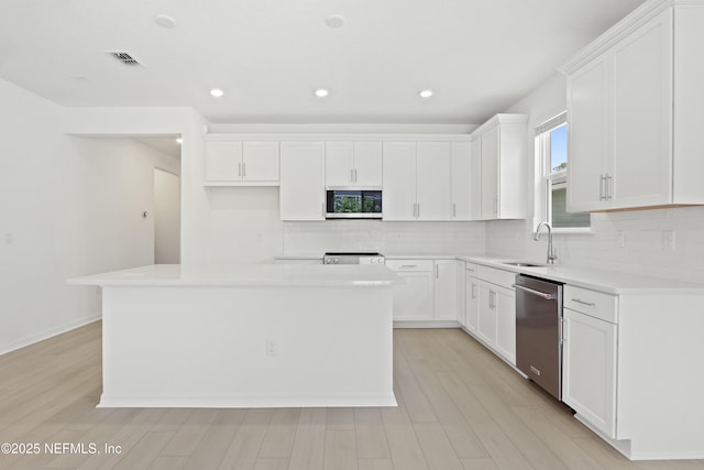 2416 Glade Ln, Green Cove Springs, FL 32043 - kitchen with stainless steel appliances, a sink, backsplash, a center island, and light wood-type flooring