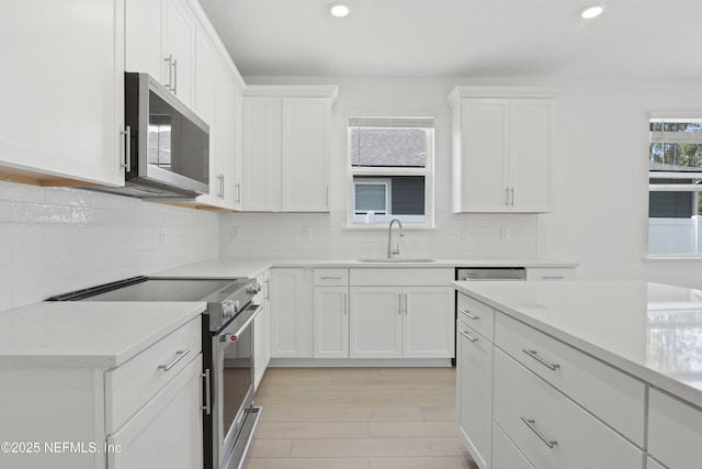 2416 Glade Ln, Green Cove Springs, FL 32043 - kitchen featuring appliances with stainless steel finishes, a sink, recessed lighting, light countertops, and white cabinets