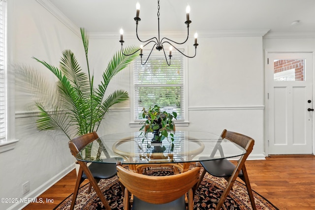 dining space featuring crown molding, a notable chandelier, and wood finished floors