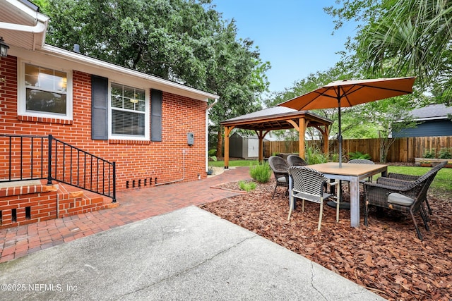 view of patio featuring a fenced backyard, outdoor dining space, and a gazebo