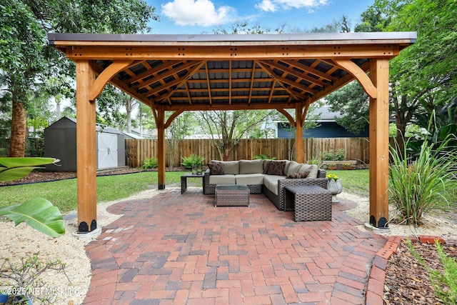 view of patio with an outdoor structure, outdoor lounge area, a fenced backyard, a storage unit, and a gazebo