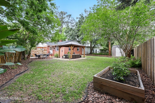 view of yard with an outdoor living space, a fenced backyard, a garden, and a shed