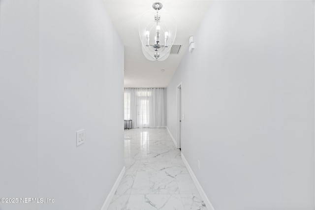132 Summerhill Cir, Saint Augustine, FL 32086 - hallway featuring light marble finish flooring and a chandelier
