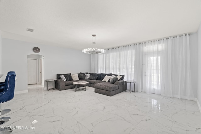 132 Summerhill Cir, Saint Augustine, FL 32086 - living room with arched walkways, marble tiled floors, and a chandelier