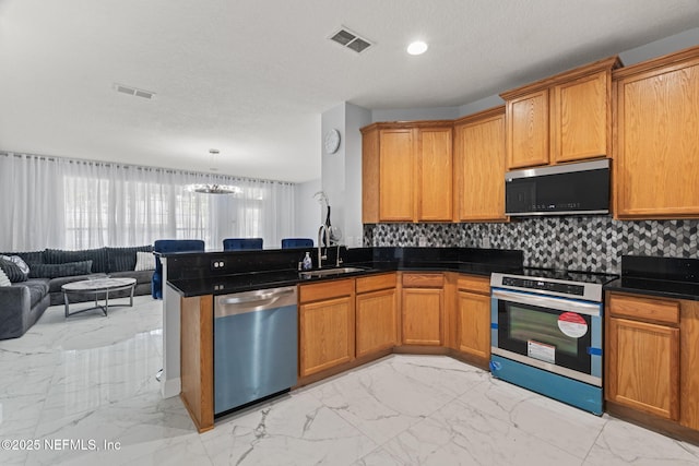 132 Summerhill Cir, Saint Augustine, FL 32086 - kitchen with appliances with stainless steel finishes, light marble finish floors, open floor plan, a chandelier, and decorative backsplash