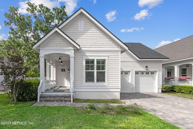 1553 Coastal Oaks Cir, Fernandina Beach, FL 32034 - view of front of home with a porch, decorative driveway, a front yard, and a garage