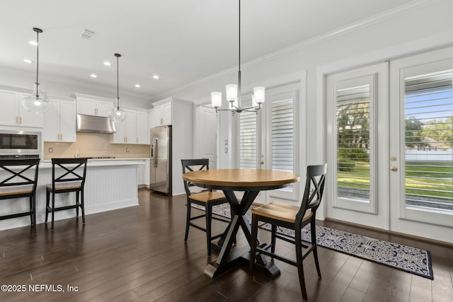1553 Coastal Oaks Cir, Fernandina Beach, FL 32034 - dining room with crown molding, a chandelier, visible vents, and dark wood-style floors