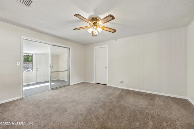 unfurnished bedroom with visible vents, carpet flooring, baseboards, and a ceiling fan