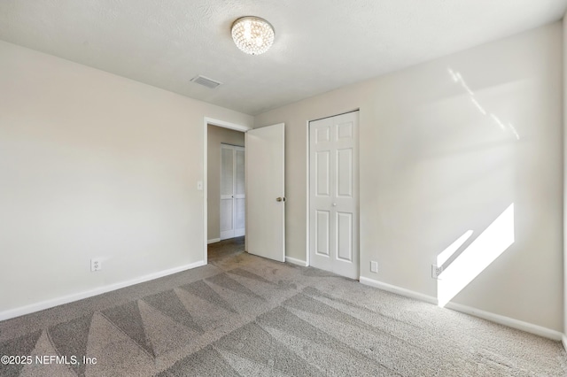 unfurnished bedroom with baseboards, carpet, and visible vents