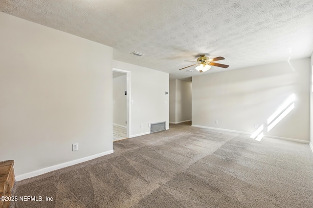 unfurnished room featuring baseboards, a ceiling fan, carpet flooring, and visible vents
