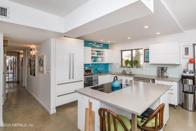2900 Coastal Hwy # 1, Saint Augustine, FL 32084 - kitchen with finished concrete flooring, modern cabinets, a sink, black appliances, and recessed lighting