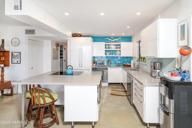 2900 Coastal Hwy # 1, Saint Augustine, FL 32084 - kitchen featuring oven, black electric stovetop, white cabinets, a sink, and concrete floors