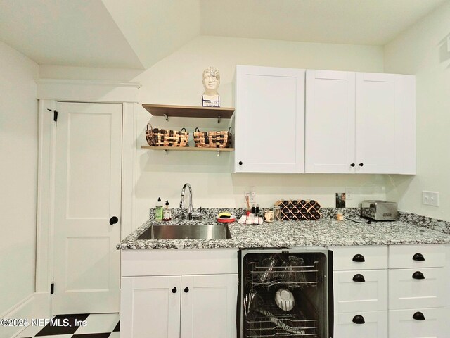 bar featuring wet bar, a sink, lofted ceiling, and dishwasher