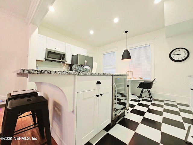 kitchen featuring appliances with stainless steel finishes, dark floors, white cabinetry, baseboards, and recessed lighting