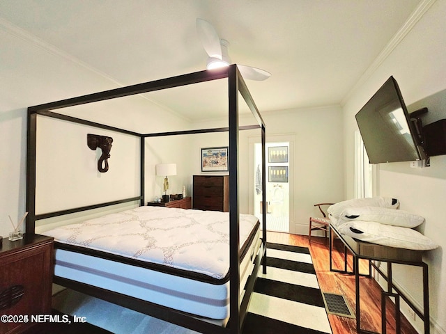 bedroom with ornamental molding and wood finished floors