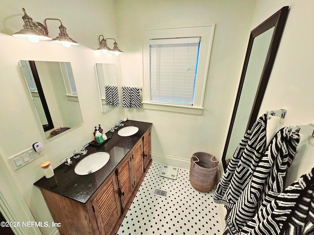 full bathroom with a sink, baseboards, and double vanity