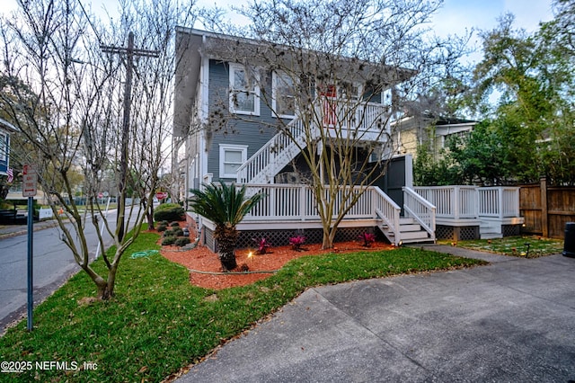 view of front of home with fence, stairway, and a deck