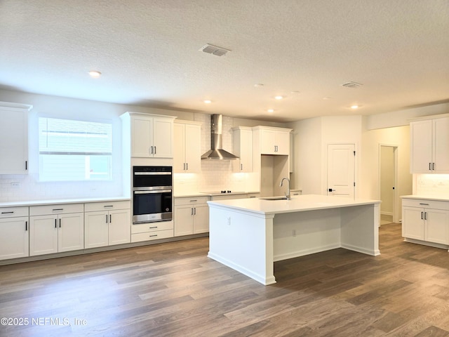 3267 Pipers Way, Green Cove Springs, FL 32043 - kitchen featuring wall chimney exhaust hood, a sink, decorative backsplash, double oven, and a textured ceiling