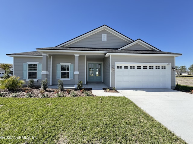 2672 Charmer Ct, Green Cove Springs, FL 32043 - view of front of house featuring a garage, a front yard, french doors, covered porch, and driveway