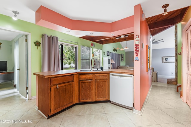 4030 Tyndel Creek Pl, Jacksonville, FL 32223 - kitchen with white dishwasher, a sink, light tile patterned floors, brown cabinets, and baseboards