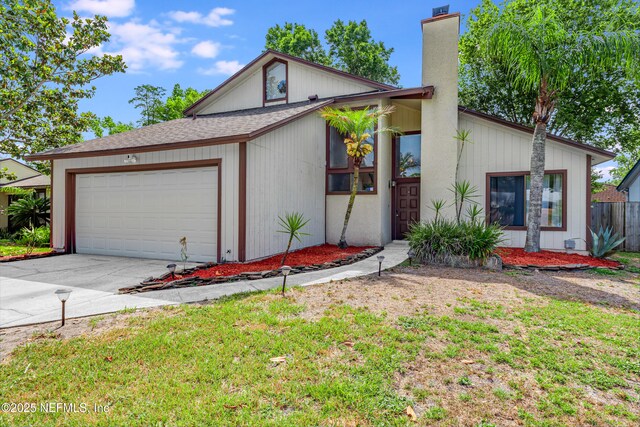 4030 Tyndel Creek Pl, Jacksonville, FL 32223 - view of front of home with an attached garage, a chimney, concrete driveway, and a shingled roof
