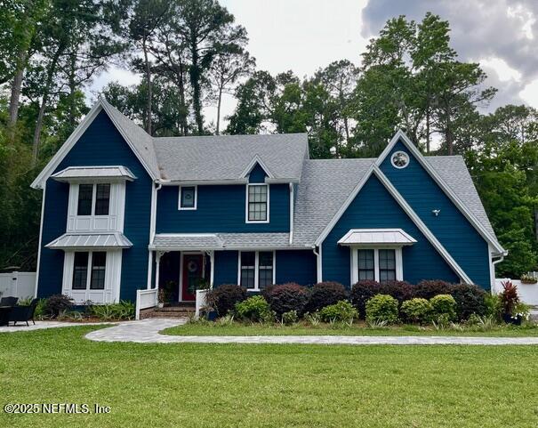 craftsman inspired home featuring a shingled roof and a front lawn