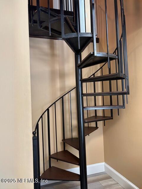 stairway with baseboards and wood finished floors