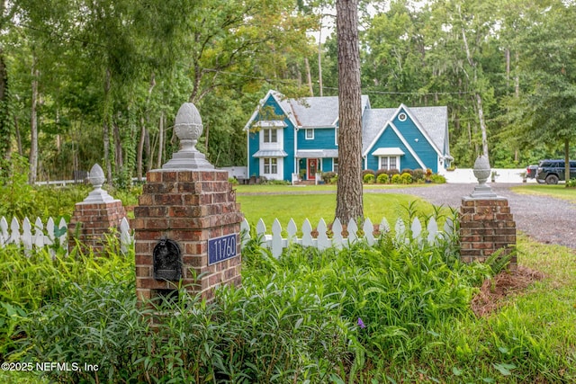 view of front of house with fence and a front lawn