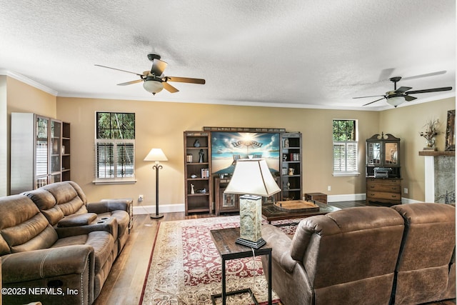 living area featuring baseboards, ceiling fan, and wood finished floors