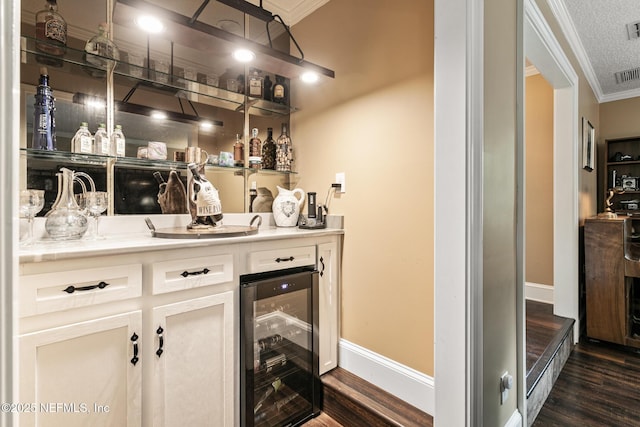 bar with crown molding, indoor wet bar, baseboards, wine cooler, and dark wood-style floors