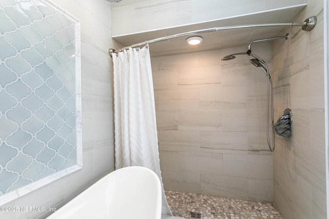 full bath featuring a washtub and a tile shower