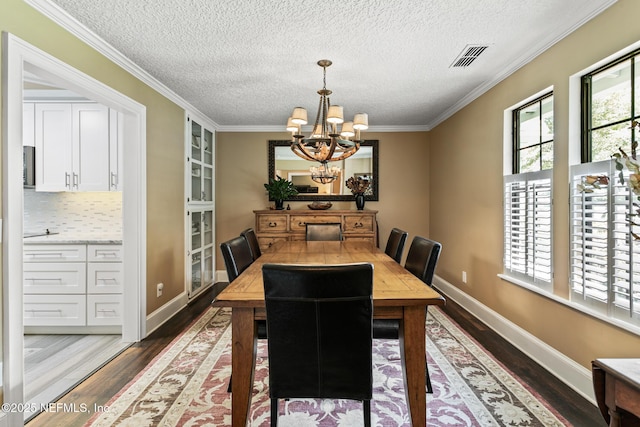 dining space featuring crown molding, a textured ceiling, wood finished floors, and a notable chandelier