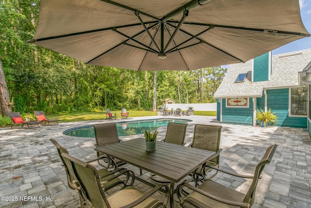 view of patio / terrace featuring fence, outdoor dining space, and an outdoor pool