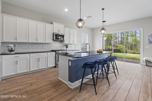 201 Bridgeton St, Saint Johns, FL 32259 - kitchen featuring white cabinets, dark countertops, stainless steel appliances, tasteful backsplash, and visible vents