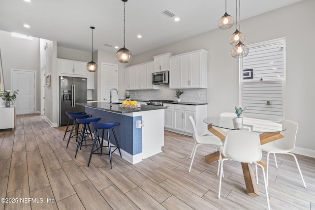 201 Bridgeton St, Saint Johns, FL 32259 - kitchen featuring stainless steel appliances, dark countertops, visible vents, and light wood-type flooring