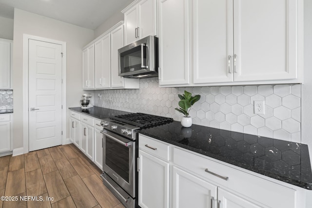 201 Bridgeton St, Saint Johns, FL 32259 - kitchen featuring dark wood-style flooring, dark stone counters, white cabinets, backsplash, and stainless steel appliances