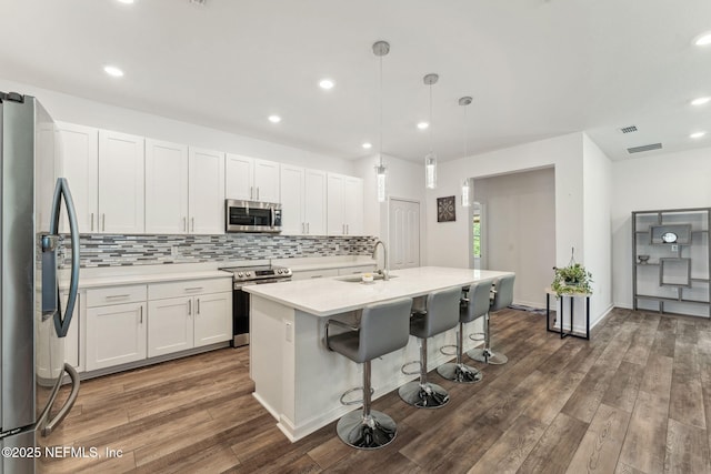 120 Oakleaf Way, Palm Coast, FL 32137 - kitchen featuring a breakfast bar area, appliances with stainless steel finishes, tasteful backsplash, a sink, and light countertops