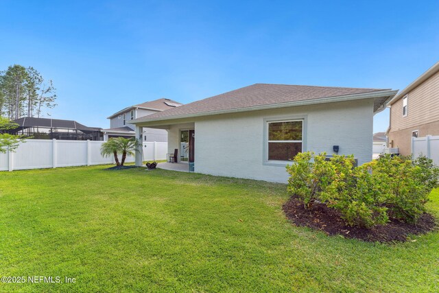 120 Oakleaf Way, Palm Coast, FL 32137 - back of property with a lawn and a fenced backyard