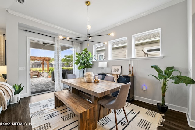 dining room featuring ornamental molding, baseboards, a chandelier, and wood finished floors