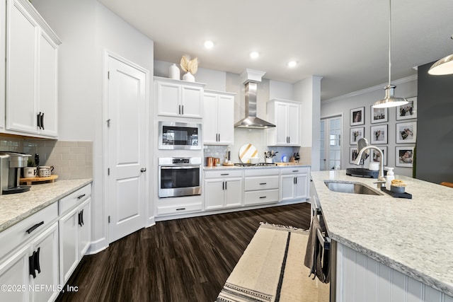 kitchen featuring stainless steel appliances, wall chimney range hood, a sink, dark wood finished floors, and white cabinetry