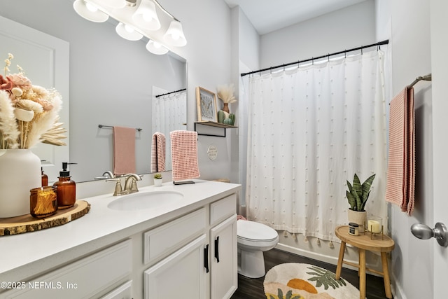 bathroom with toilet, wood finished floors, vanity, and shower / bath combo with shower curtain