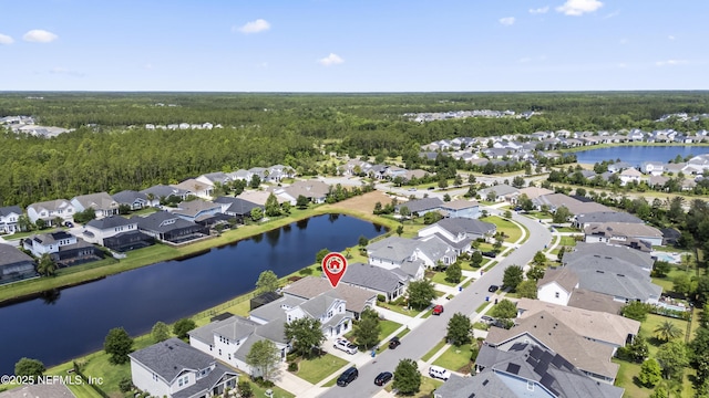 aerial view of property's location with nearby suburban area, a forest, and a large body of water
