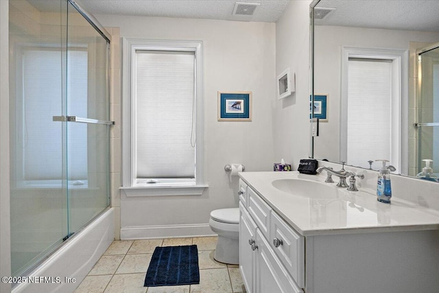 bathroom featuring baseboards, toilet, tile patterned floors, vanity, and enclosed tub / shower combo
