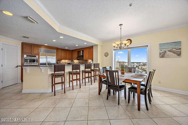 dining room with a textured ceiling, crown molding, a chandelier, light tile patterned floors, and baseboards
