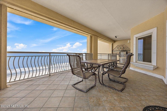 balcony with exterior kitchen and view of water and beach