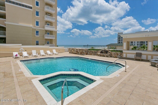 view of swimming pool with a patio area and a pool with connected hot tub