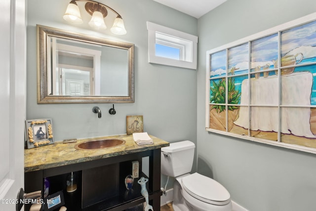 bathroom featuring vanity, baseboards, and toilet
