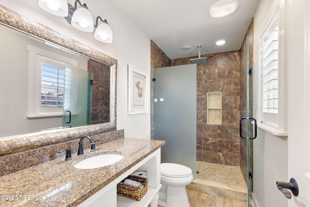 full bathroom featuring toilet, visible vents, a shower stall, and vanity