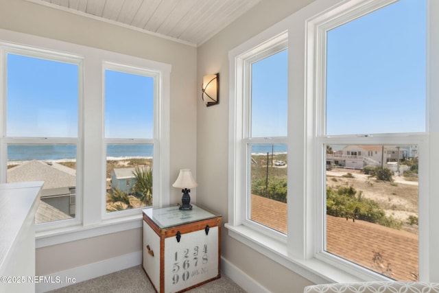 sunroom featuring a water view